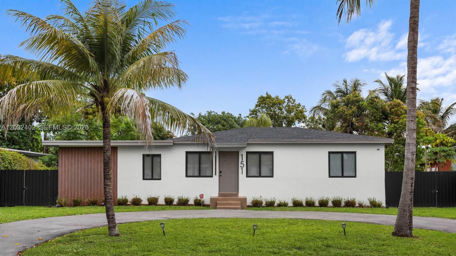 A single-story white house with a dark roof, wood accents, and a curved driveway — 151 NW 146th St # 151, Miami FL 33168, MIAMI, FL