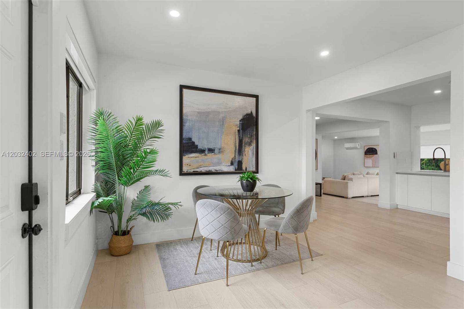 A dining area features a glass-topped table, grey upholstered chairs, and a large abstract painting — 151 NW 146th St # 151, Miami FL 33168, MIAMI, FL