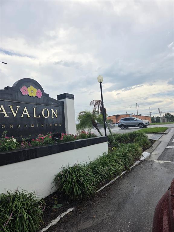 A sign for Avalon Condominiums stands near a road with a silver car passing by — 4203 S SEMORAN BOULEVARD UNIT 4, ORLANDO, FL