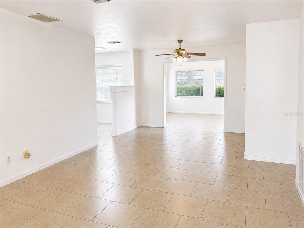 An interior view of a room with light-colored tile flooring and a ceiling fan — 10964 84TH AVENUE, SEMINOLE, FL
