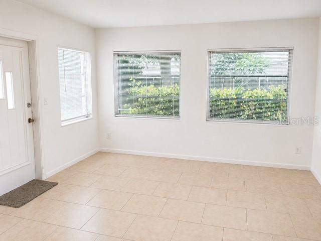A bright room with light-colored tile flooring, white walls, and three windows with blinds — 10964 84TH AVENUE, SEMINOLE, FL