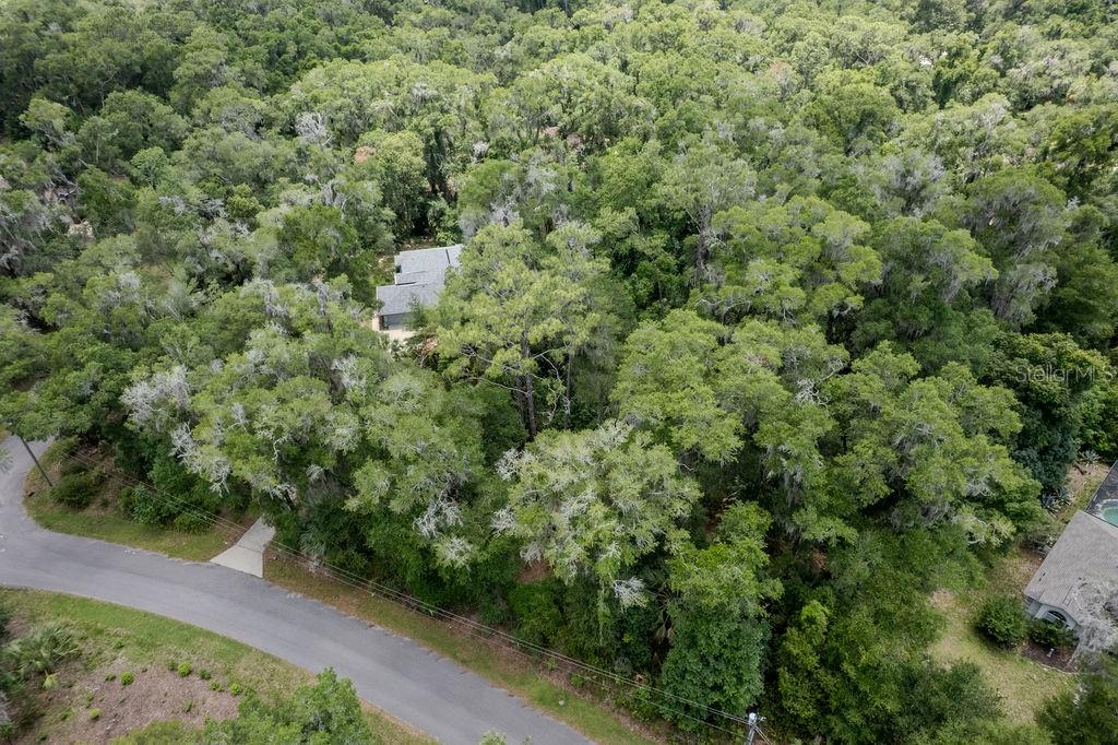An aerial view shows a house nestled within a dense, tree-covered lot near a road — Lot 6 SW 186 CIRCLE, DUNNELLON, FL