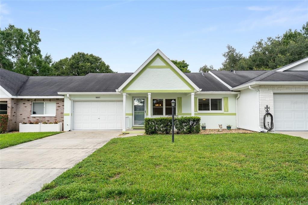 A single-story house with a white garage, light green trim, and a concrete driveway — 9660 SW 92ND COURT UNIT C, OCALA, FL