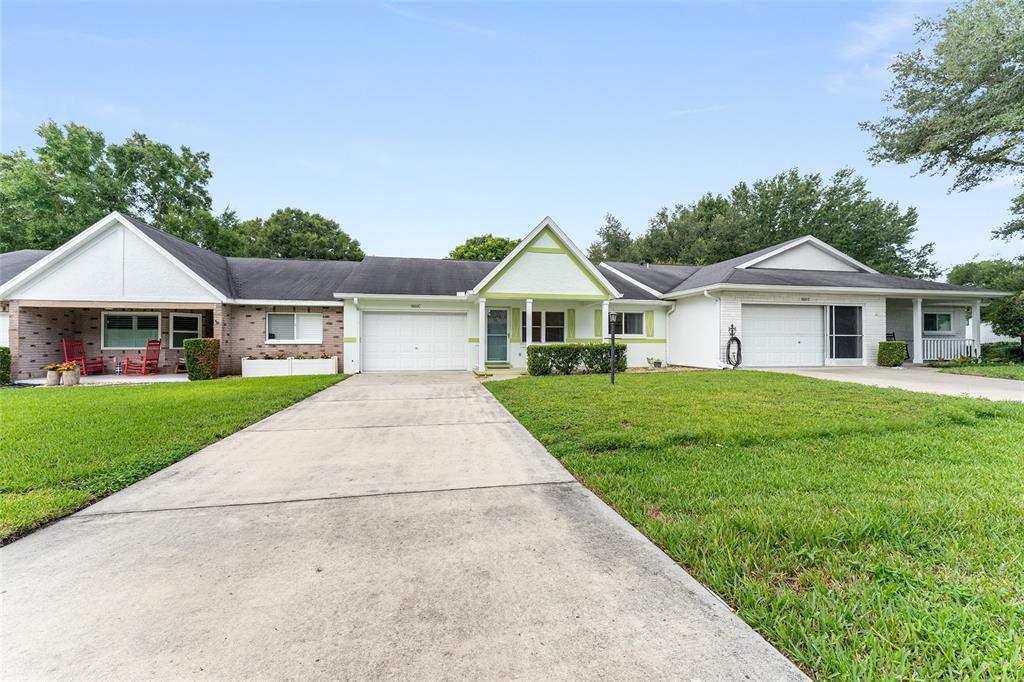 A single-story house with a white garage, light green trim, and a front lawn — 9660 SW 92ND COURT UNIT C, OCALA, FL