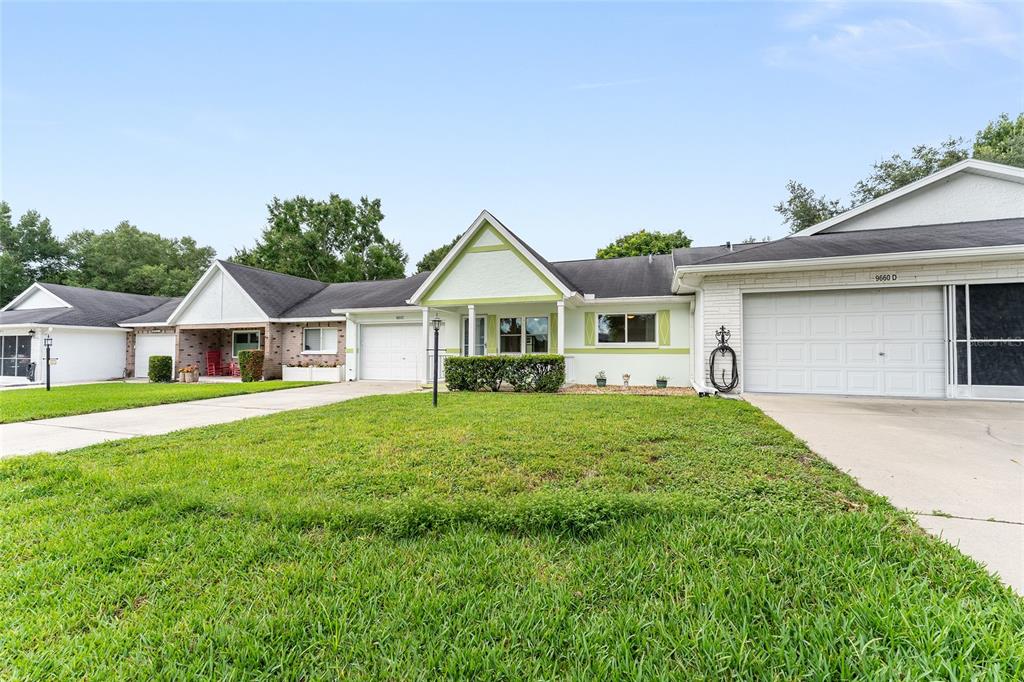 The exterior of a single-story house features a screened-in porch and a grassy backyard — 9660 SW 92ND COURT UNIT C, OCALA, FL