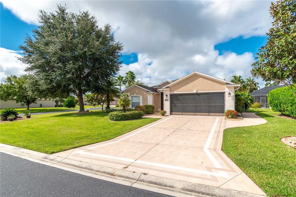 A single-story house with a beige exterior, a screened garage door, and a paved driveway — 15692 SW 11TH COURT ROAD, OCALA, FL