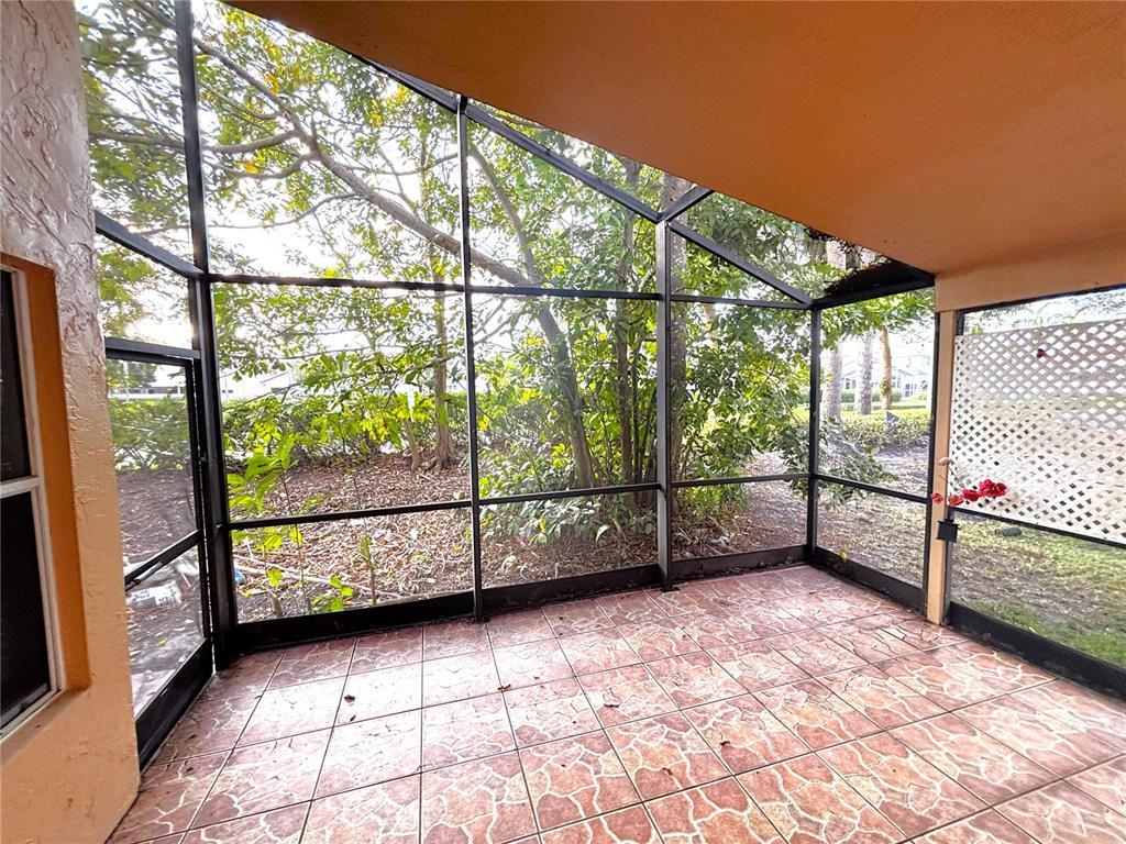 A screened-in patio features tiled flooring and views of trees and landscaping — 510 SW 181ST WAY, PEMBROKE PINES, FL