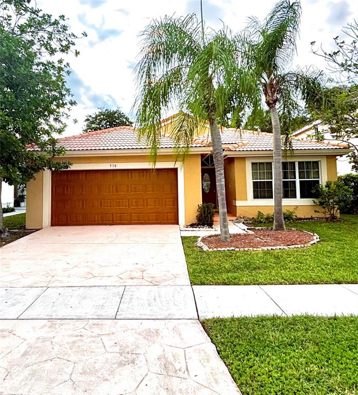 A single-story house with a tan exterior, a two-car garage, and two palm trees — 510 SW 181ST WAY, PEMBROKE PINES, FL