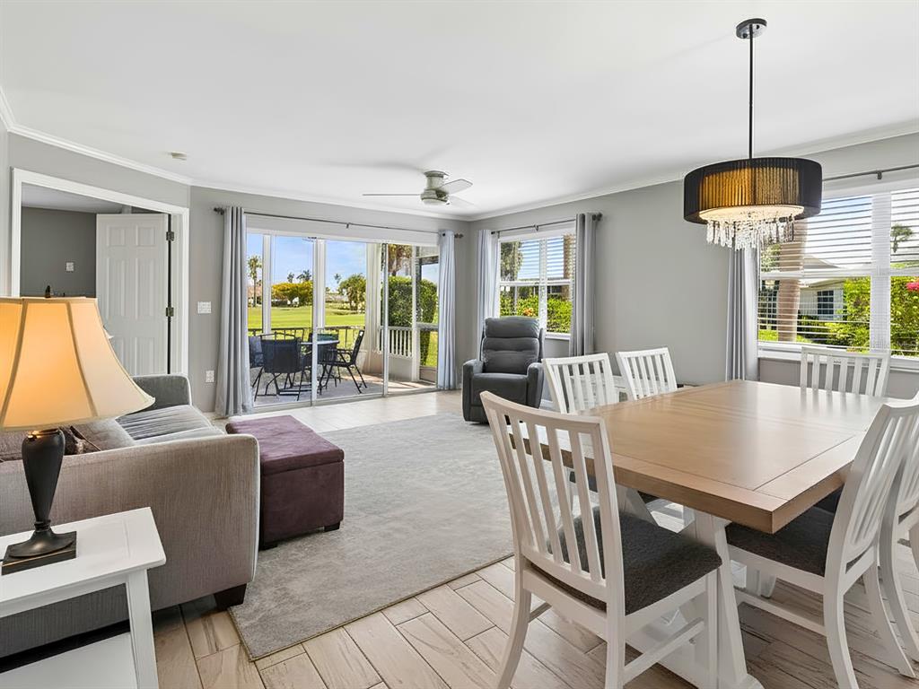 A living and dining area features light tile floors, a sliding door, and golf course views — 1612 FAIRWAY TRACE UNIT A, PALMETTO, FL