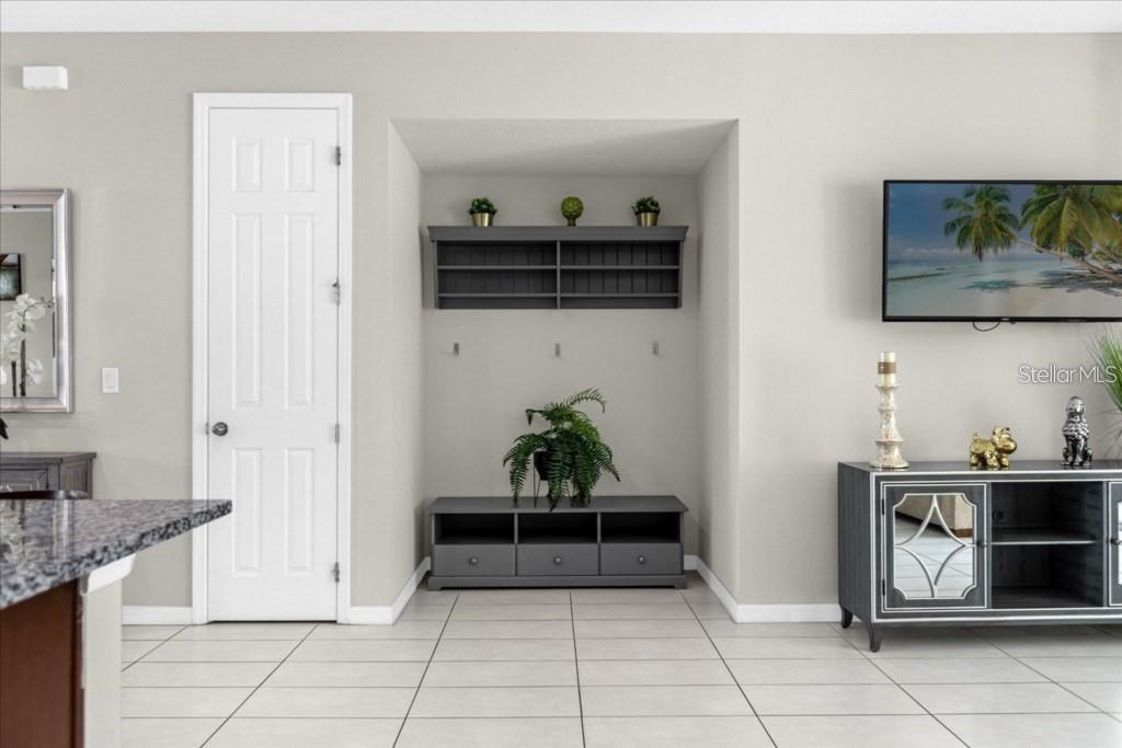 A living room features a recessed wall niche with shelving, a console table, and tile flooring — 1540 CAREY PALM CIRCLE, KISSIMMEE, FL