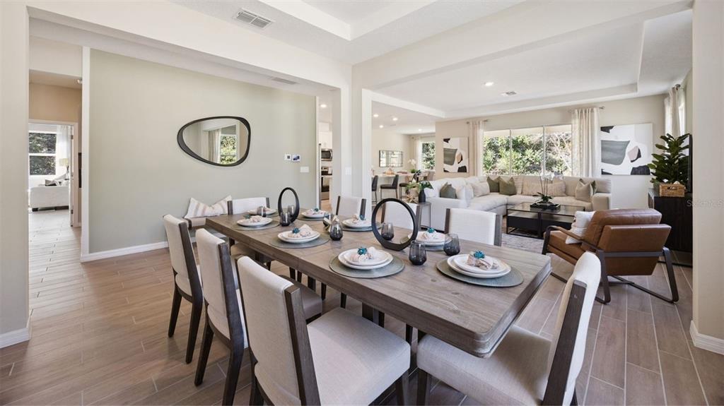 A dining room with a wooden table and chairs opens into a living area — 3050 KINGSMAN TRAIL, ORMOND BEACH, FL