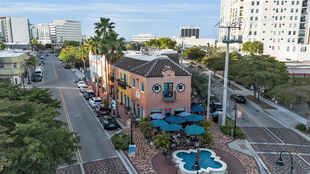 An aerial view shows a multi-story building with a restaurant patio and a fountain — 530 S ORANGE AVENUE, SARASOTA, FL
