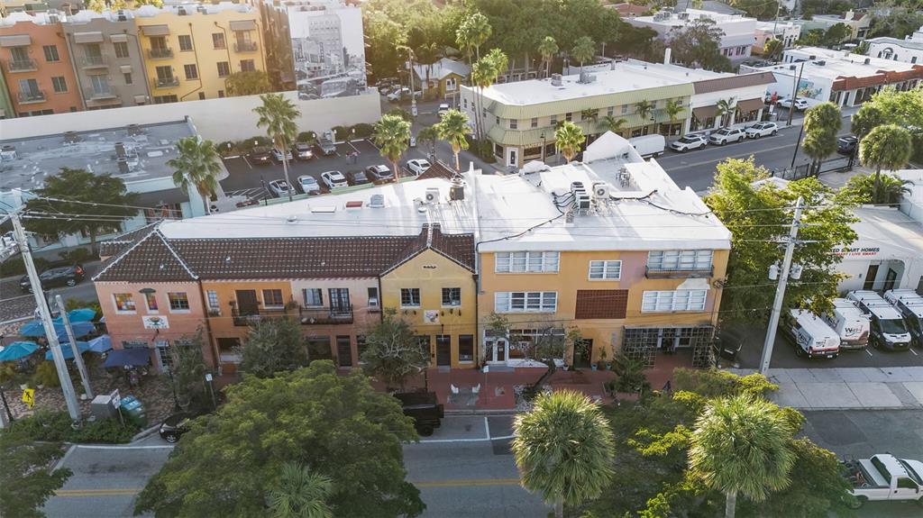 An aerial view shows a multi-story commercial building with a tiled roof and surrounding parking — 530 S ORANGE AVENUE, SARASOTA, FL