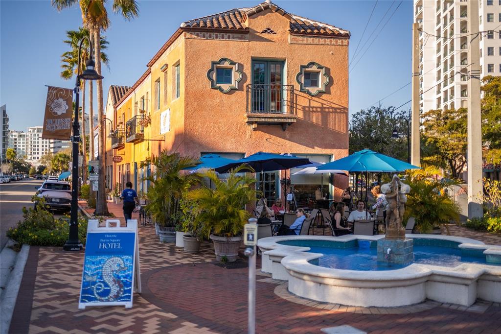 An outdoor patio with a fountain and seating sits in front of a Mediterranean-style building — 530 S ORANGE AVENUE, SARASOTA, FL