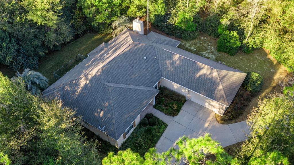 An aerial view shows a single-story house with a shingled roof and a concrete driveway — 20698 SW 93RD LANE ROAD, DUNNELLON, FL