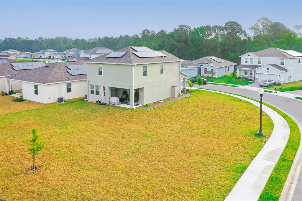 An exterior view of a two-story house with solar panels on a large corner lot — 3027 CAMDEN WAY, DAVENPORT, FL