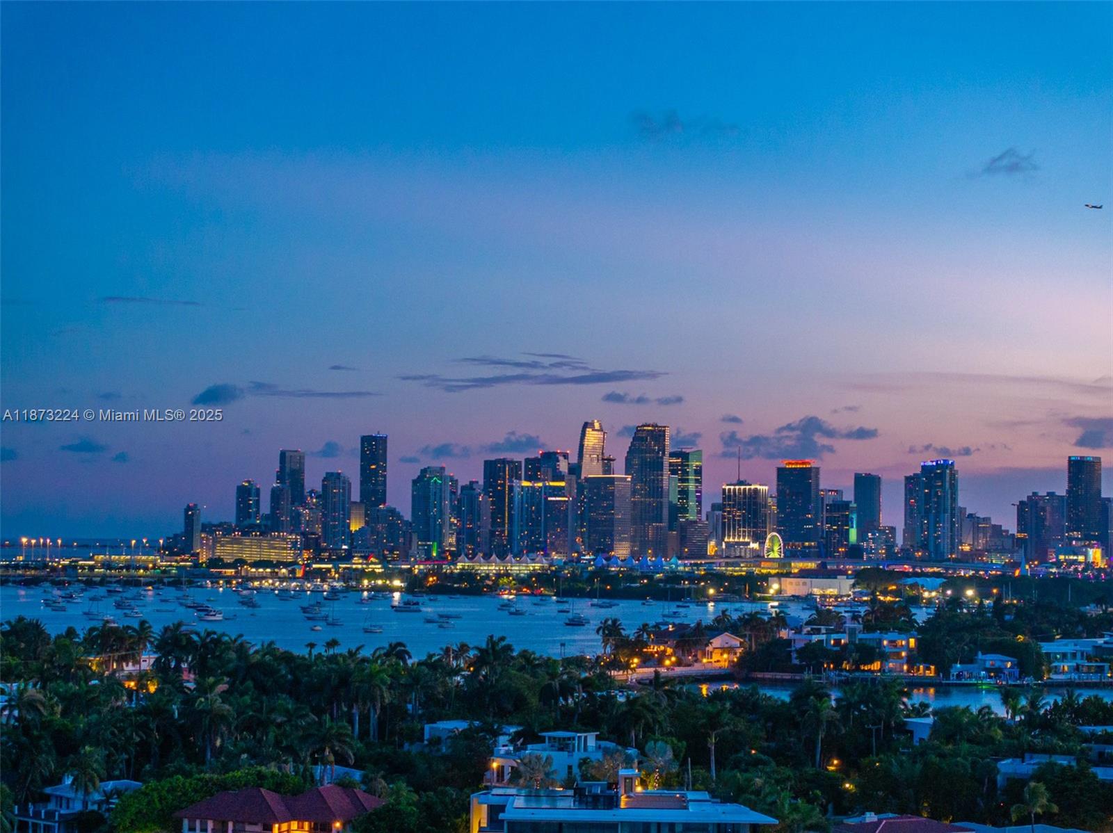 A wide-angle view of the Miami skyline at dusk overlooking a bay with boats — 814 W Dilido Dr, Miami Beach FL 33139, MIAMI BEACH, FL