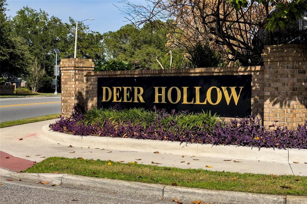 A brick monument sign with the words Deer Hollow sits beside a road — 2836 SPIVEY LANE, ORLANDO, FL