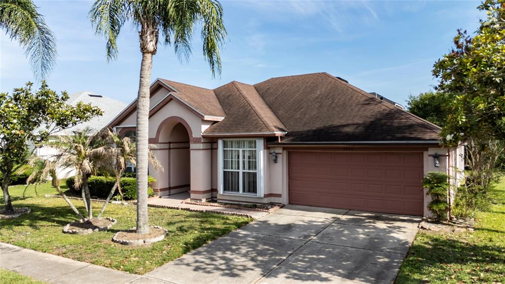 A single-story house with a brown roof, tan stucco exterior, and a two-car garage — 2836 SPIVEY LANE, ORLANDO, FL