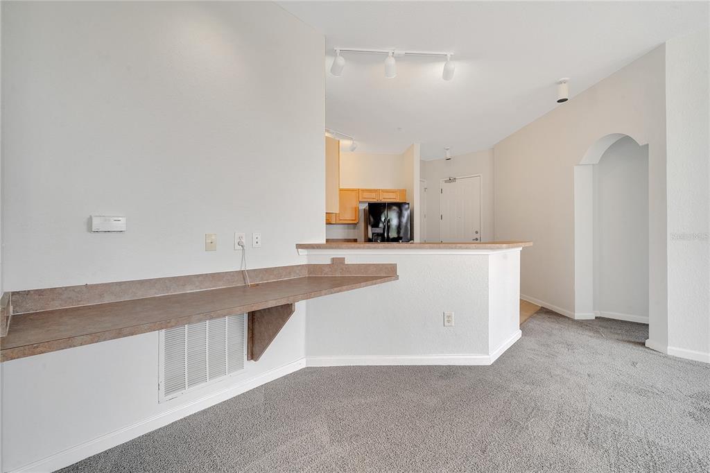 A living area features a built-in desk, carpeted flooring, and a kitchen pass-through counter — 817 TERRACE RIDGE CIRCLE UNIT 817, DAVENPORT, FL