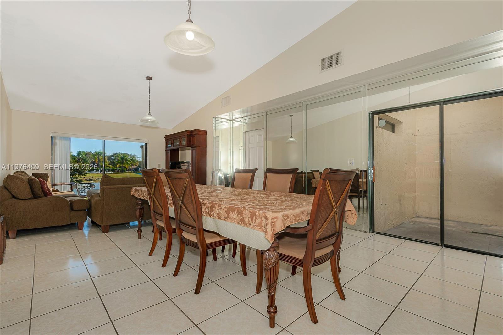 A dining room with a table and chairs sits adjacent to a living area — 840 SW 120th Way, Davie FL 33325, DAVIE, FL