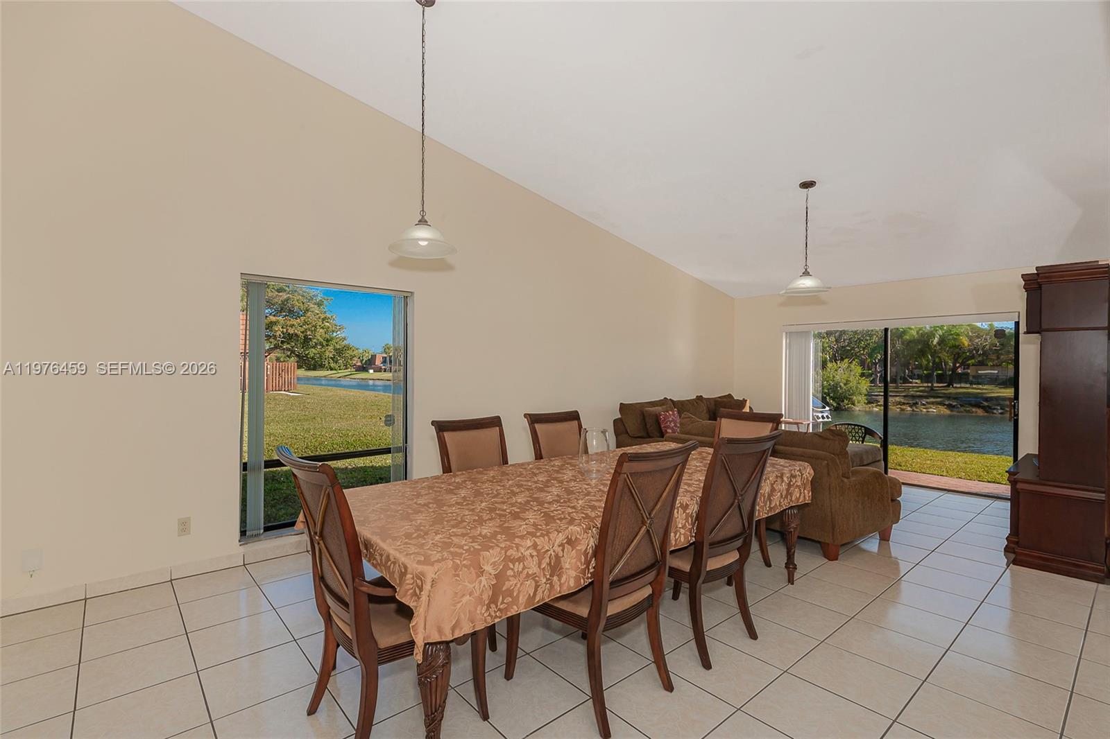 A dining area with a table and chairs features tiled floors and views of a lake — 840 SW 120th Way, Davie FL 33325, DAVIE, FL