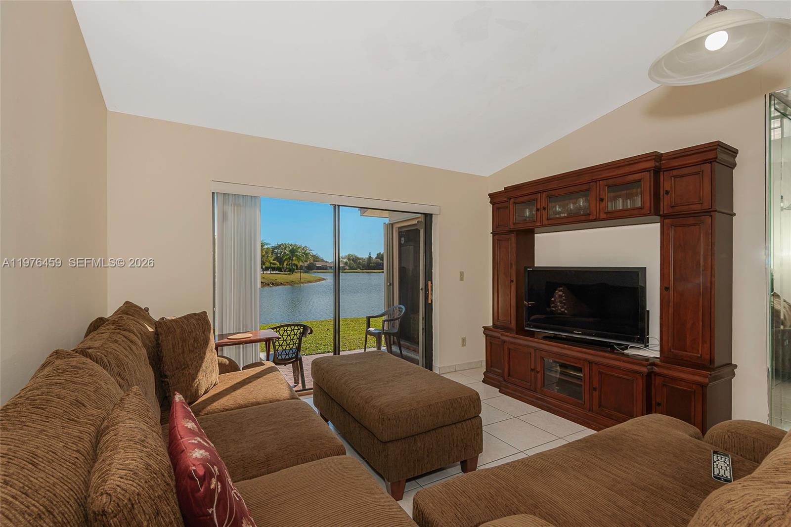 A living room features a brown sectional sofa, an entertainment center, and sliding glass doors — 840 SW 120th Way, Davie FL 33325, DAVIE, FL