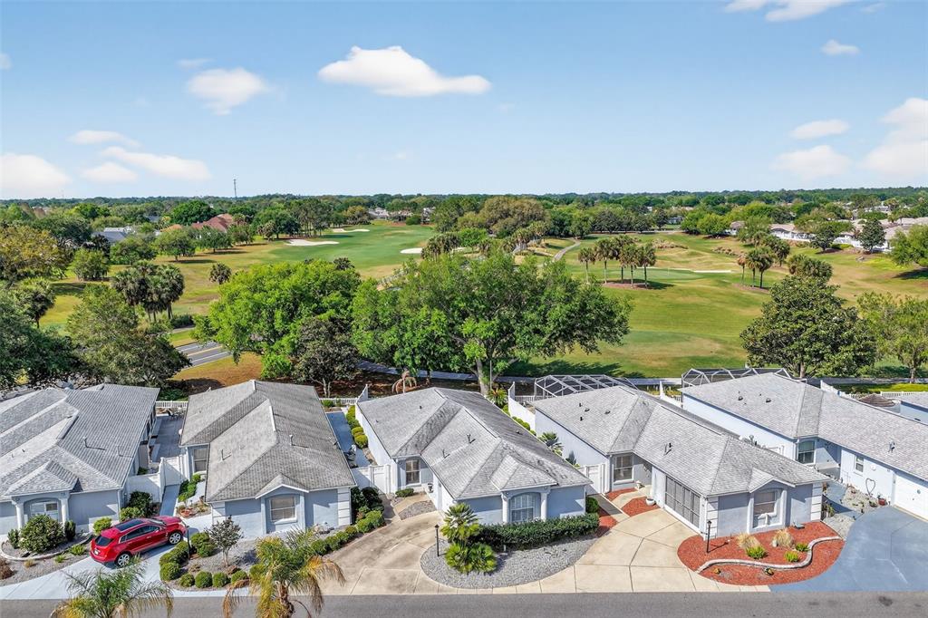 An aerial view of several single-story houses situated next to a golf course — 1808 PEACHTREE AVENUE, THE VILLAGES, FL