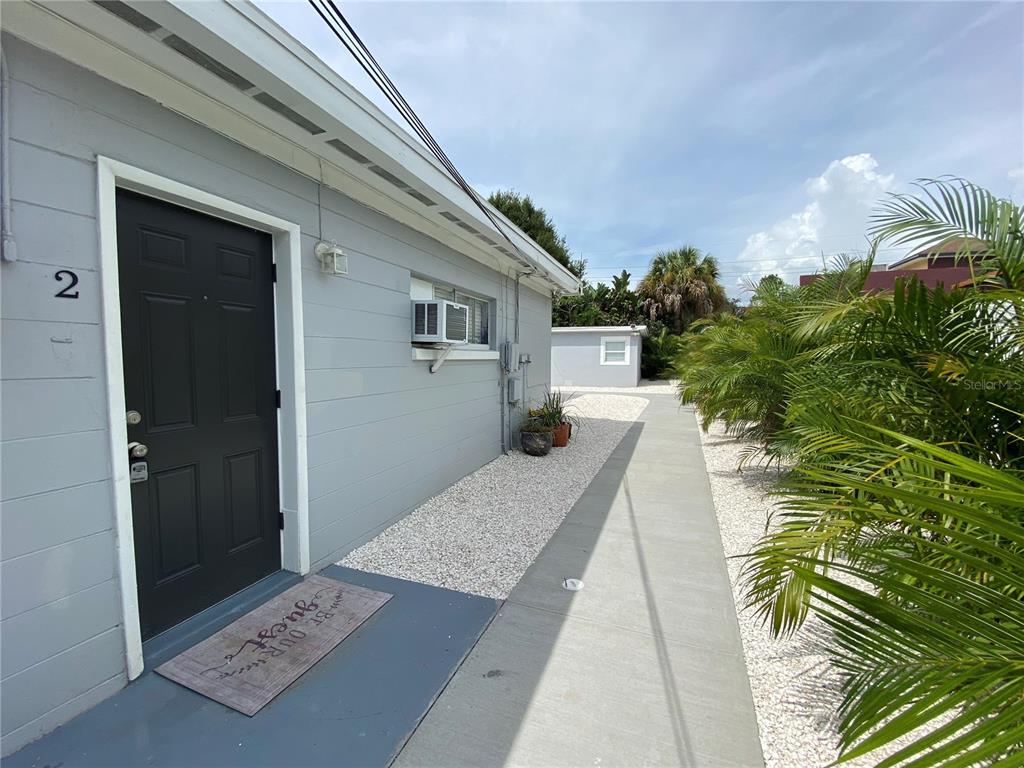 A gray exterior wall with a black door labeled number two and a concrete walkway — 3805 W LEONA STREET UNIT 2, TAMPA, FL