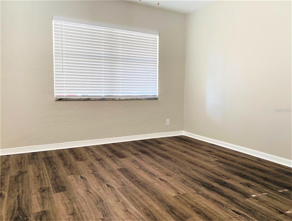 An empty room with light-colored walls, white trim, and dark wood-look flooring — 3805 W LEONA STREET UNIT 2, TAMPA, FL