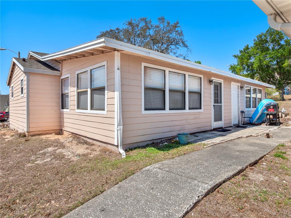 A single-story house with light pink siding, white trim, and a concrete walkway — 10301 S U S HIGHWAY 27 UNIT 172, CLERMONT, FL