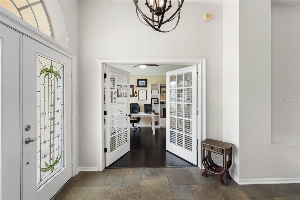 A foyer with tile flooring leads through French doors into a home office — 9104 CYPRESS KEEP LANE, ODESSA, FL