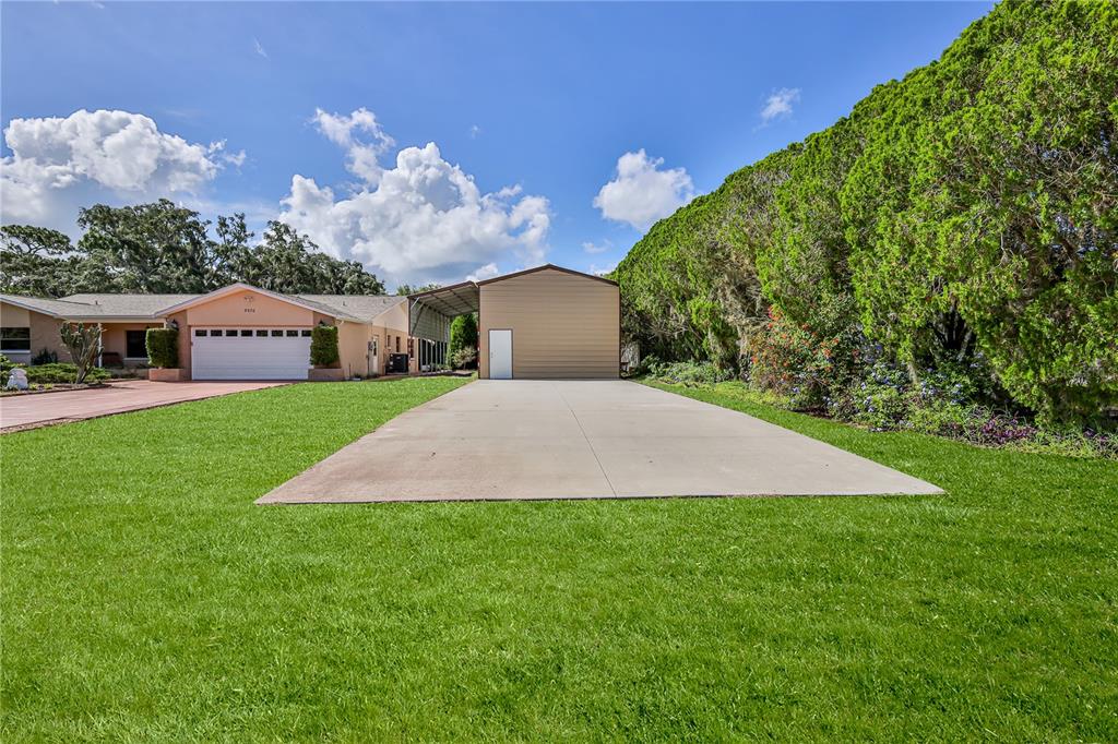 A house with an attached garage and a detached metal workshop with a concrete driveway — 8270 SYCAMORE DRIVE, NEW PORT RICHEY, FL