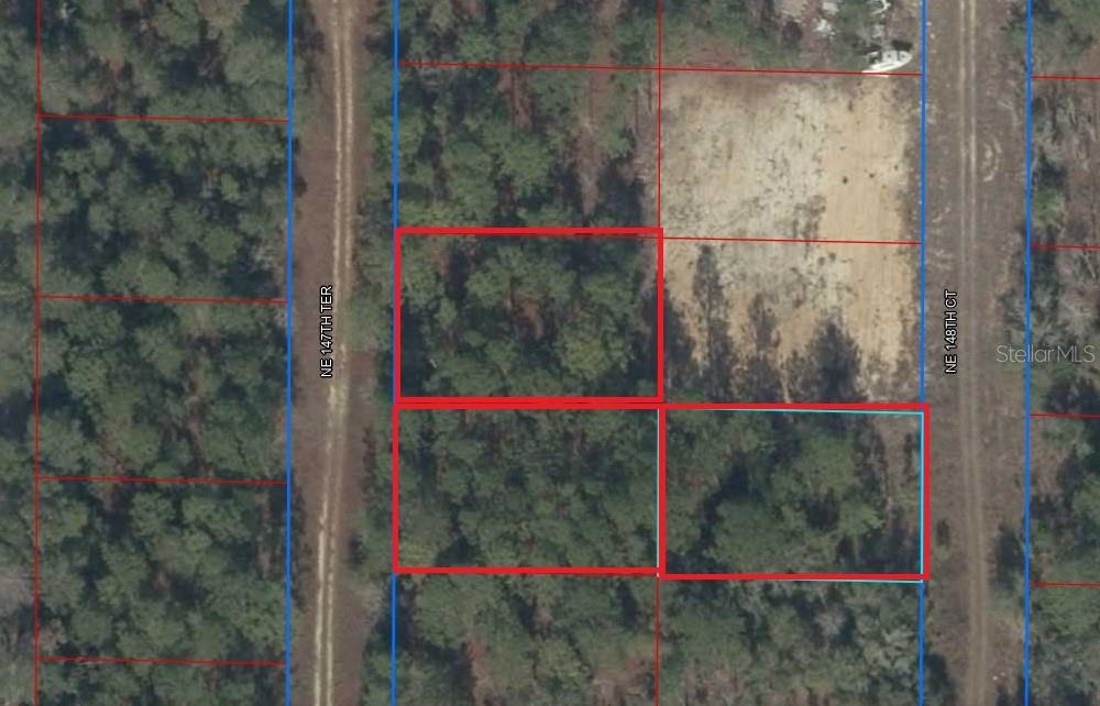 This is an aerial map showing several rectangular land parcels outlined in red and blue — TBD NE 147TH TERRACE, WILLISTON, FL
