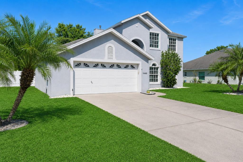 A two-story gray house with a two-car garage and palm trees on the lawn — 1483 SURREY PARK DRIVE, PORT ORANGE, FL