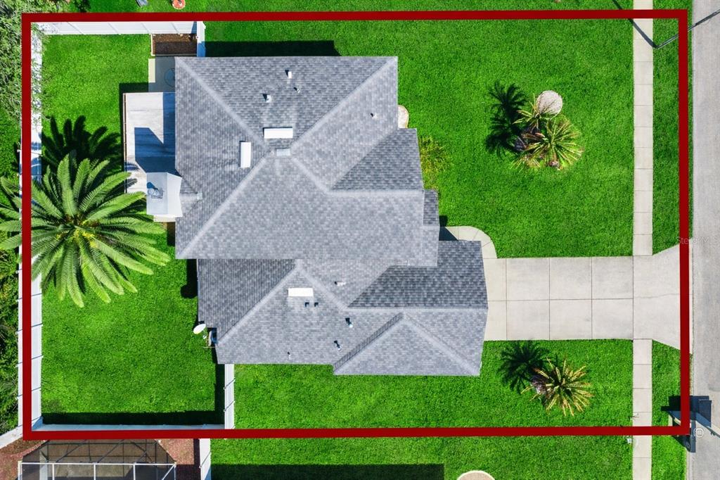 An aerial view shows a house with a gray shingled roof surrounded by green lawns — 1483 SURREY PARK DRIVE, PORT ORANGE, FL