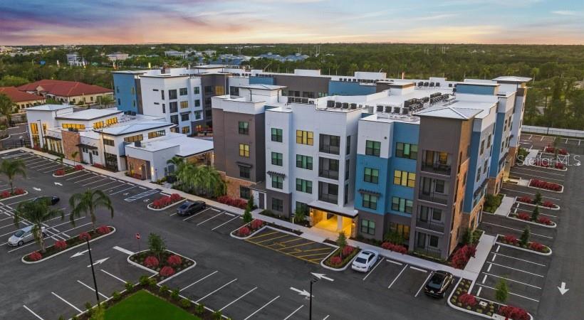 An aerial view of a multi-story apartment complex with a large parking lot — 8925 77TH TERRACE E UNIT B3-S, LAKEWOOD RANCH, FL