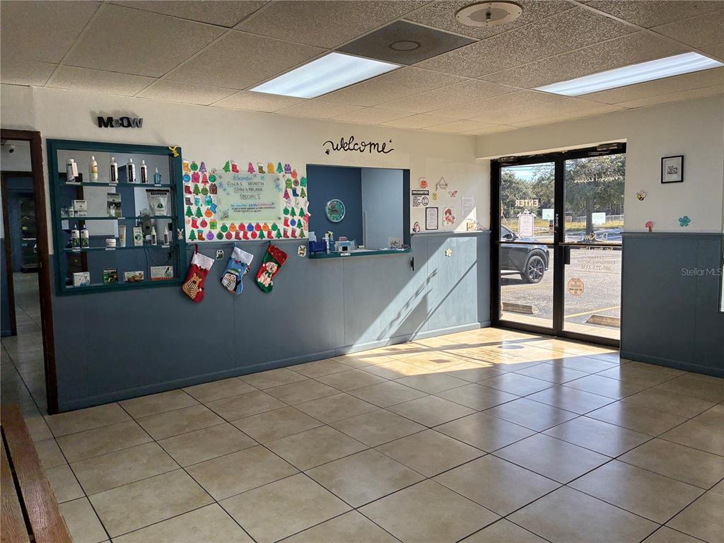 A waiting room features tiled floors, a reception window, a product display shelf, and stockings — 5745 PERSHING AVENUE, ORLANDO, FL