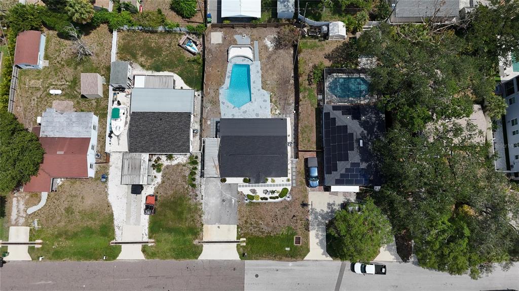An aerial view shows three residential properties with swimming pools, driveways, and surrounding trees — 4711 W LAWN AVENUE, TAMPA, FL