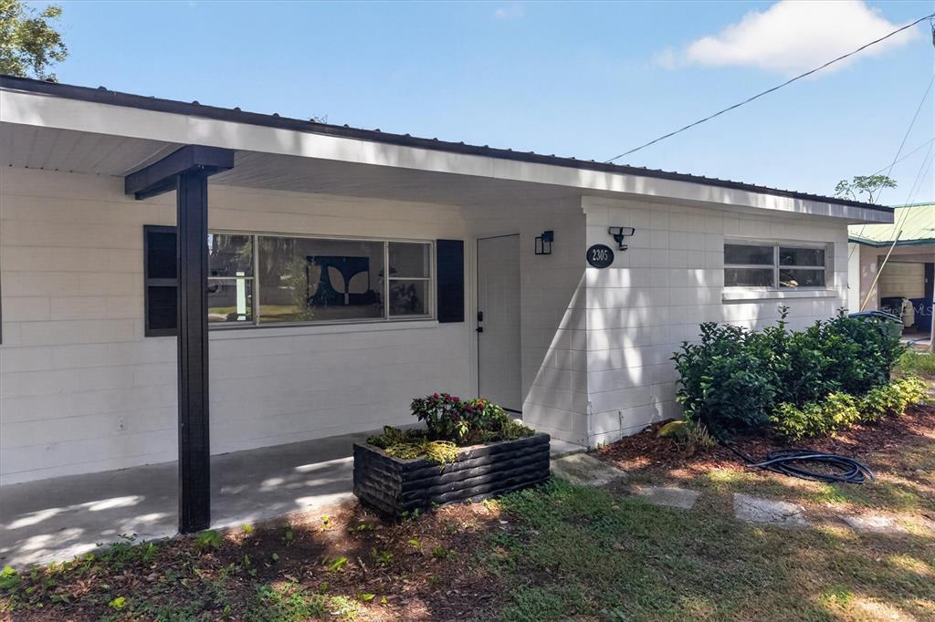 A white concrete block house with a covered front porch and a black planter box — 2305 NEW JERSEY ROAD, LAKELAND, FL