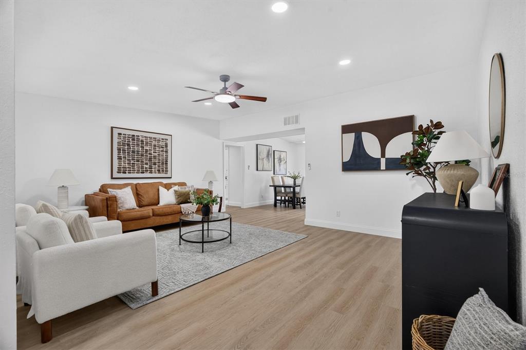 A living room features light wood flooring, a brown sofa, white armchairs, and a rug — 2305 NEW JERSEY ROAD, LAKELAND, FL
