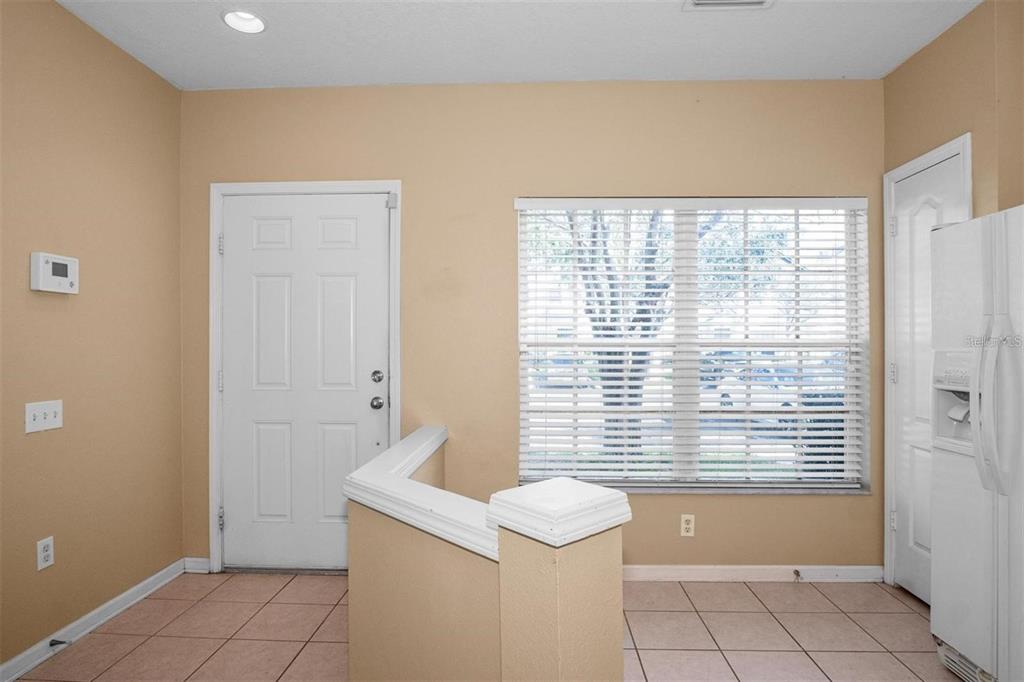 A room with tan walls, tile flooring, a white door, and a window with blinds — 4517 KENNEWICK PLACE, RIVERVIEW, FL