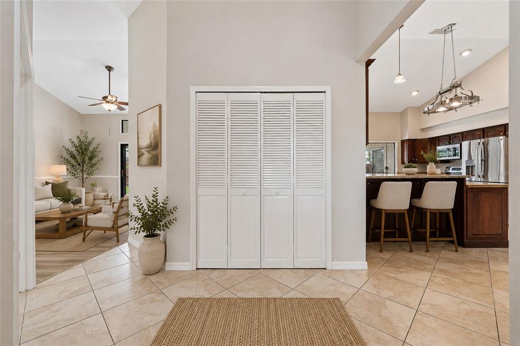 A tiled entryway features a white louvered closet door, a jute rug, and adjacent living areas — 665 ROSEMERE CIRCLE, ORLANDO, FL