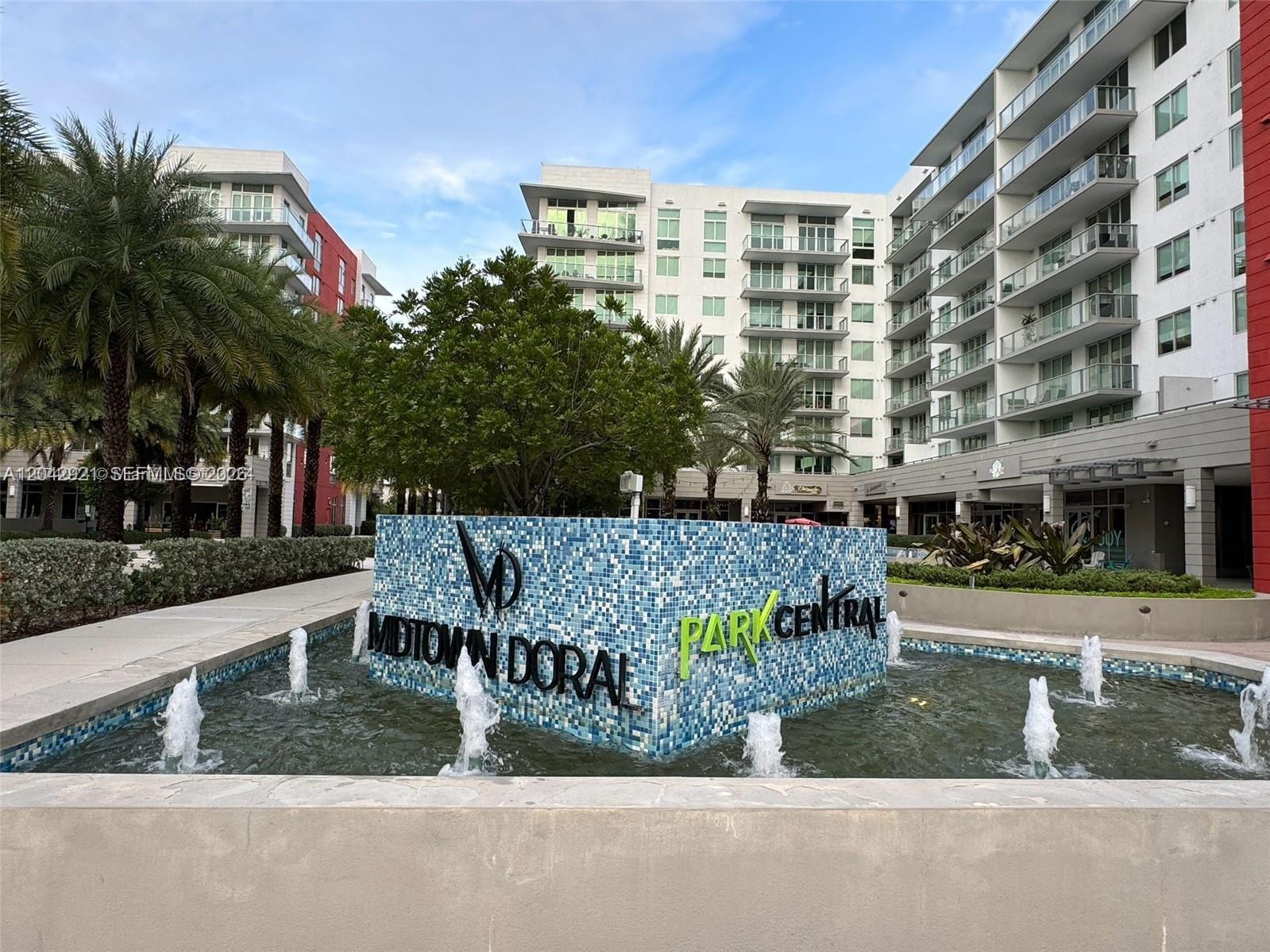 A fountain with a tiled sign for Midtown Doral Park Central sits before modern apartment buildings — 7825 NW 107th Ave # 706, Doral FL 33178, DORAL, FL