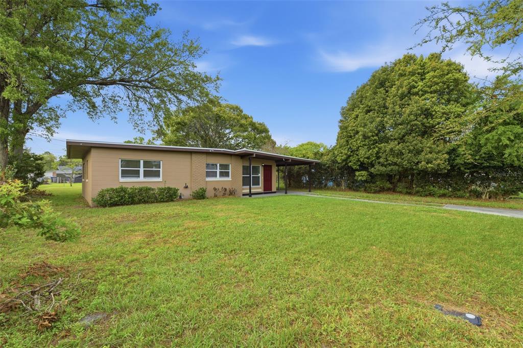 A single-story house with a tan exterior, a covered porch, and a large front lawn — 116 HOPE CIRCLE, ORLANDO, FL
