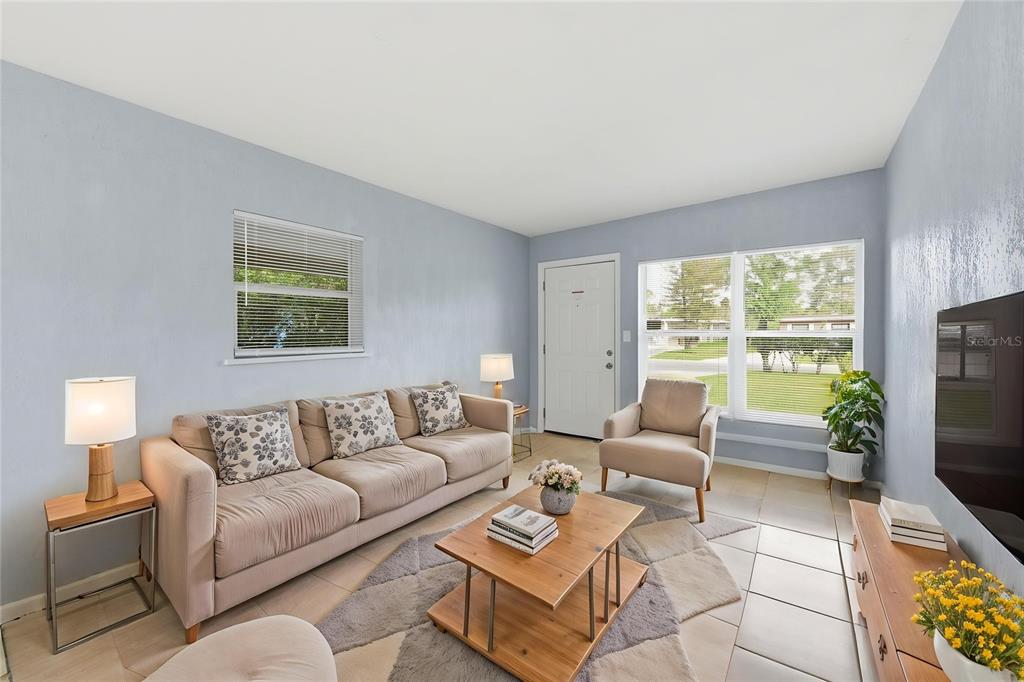 A living room features light blue walls, tile flooring, a beige sofa, and a coffee table — 116 HOPE CIRCLE, ORLANDO, FL
