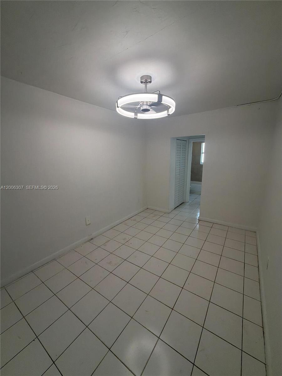 A small room with white walls, white tile flooring, and a modern ceiling fan light — 3669 Thomas Ave # 10, Miami FL 33133, MIAMI, FL