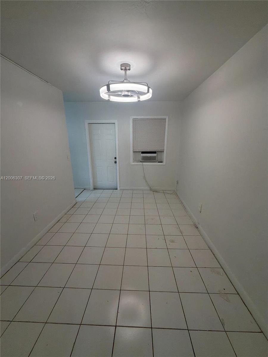 A room with white walls, white tile flooring, a ceiling fan, and a window air conditioner — 3669 Thomas Ave # 10, Miami FL 33133, MIAMI, FL