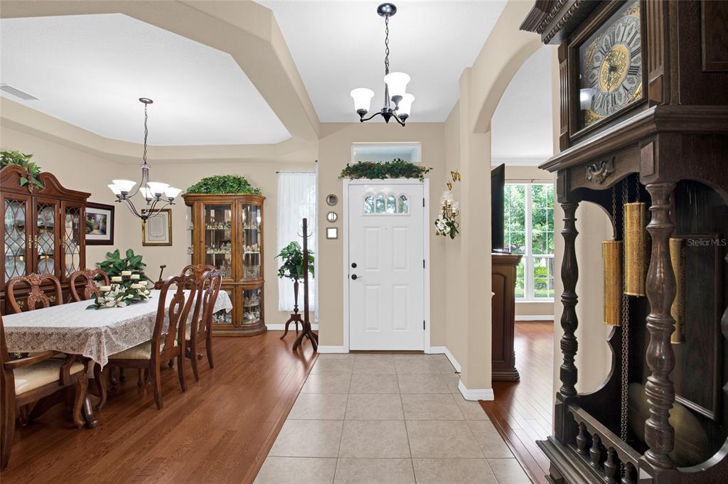 A dining room with a wooden table and hutch sits adjacent to a tiled entryway — 16411 SW 14TH AVENUE ROAD, OCALA, FL
