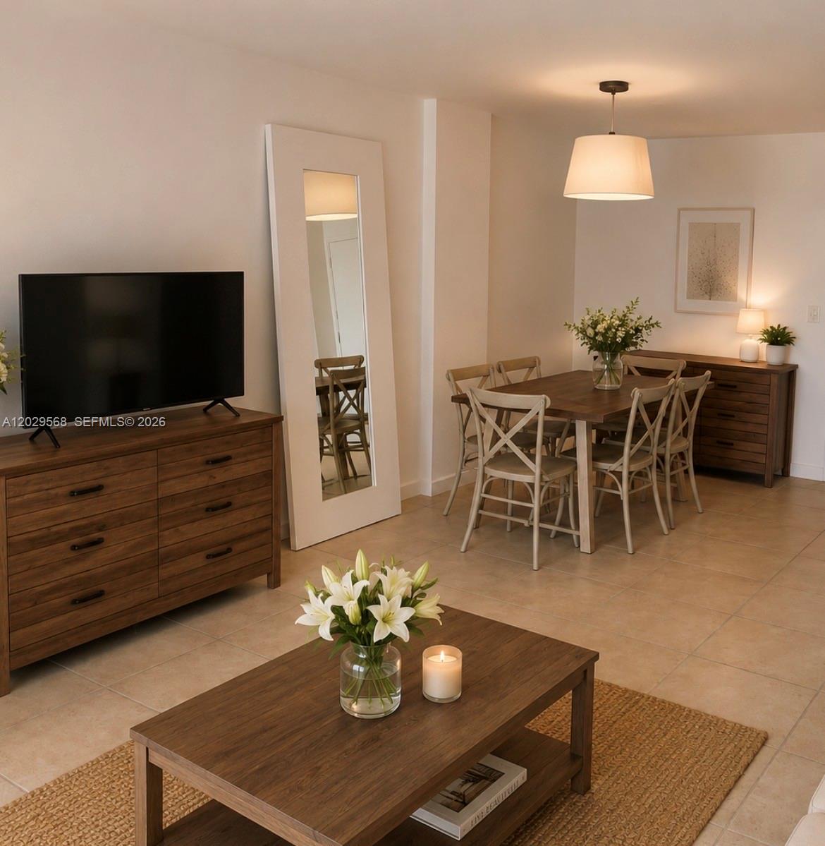 A living and dining area features wood furniture, a large floor mirror, and tile flooring — 800 West Ave # 715, Miami Beach FL 33139, MIAMI BEACH, FL